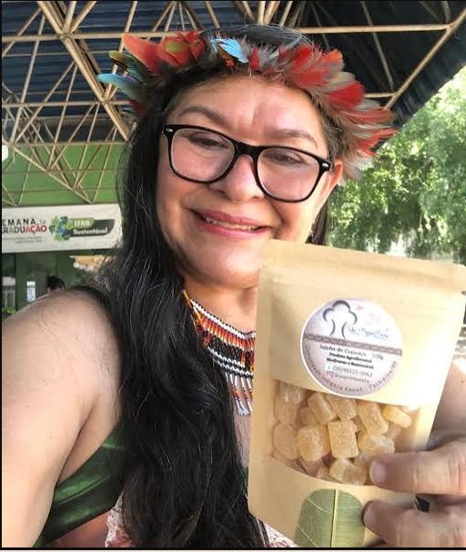 Dona Vera com adorno indígena apresentando a jujuba de cupuaçu Yu’Primavera